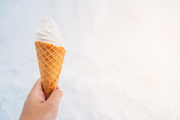 Hand, die Eiscreme mit Kegel hält