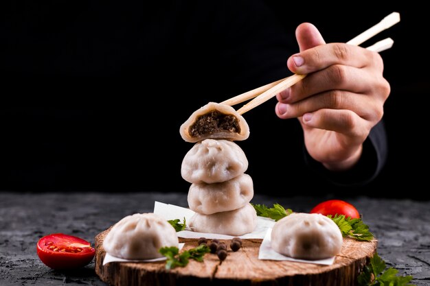 Hand, die Essstäbchen mit Mehlkloß hält