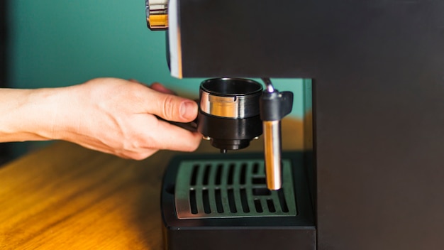 Hand, die Filter in Espressomaschine installiert