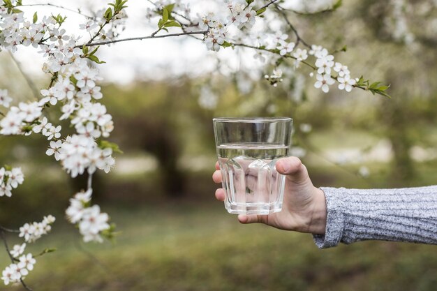 Hand, die Glas draußen Nahaufnahme hält