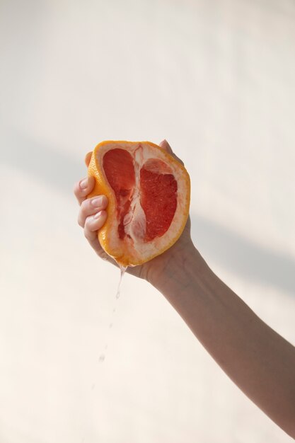 Hand, die Grapefruitsommerzeit hält