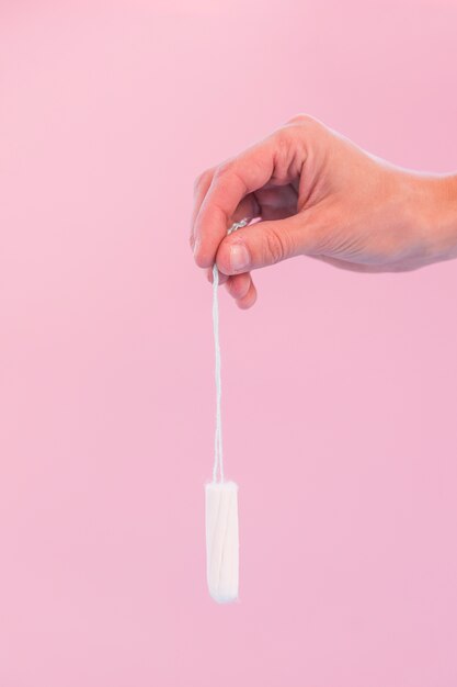 Hand, die hängenden Tampon hält