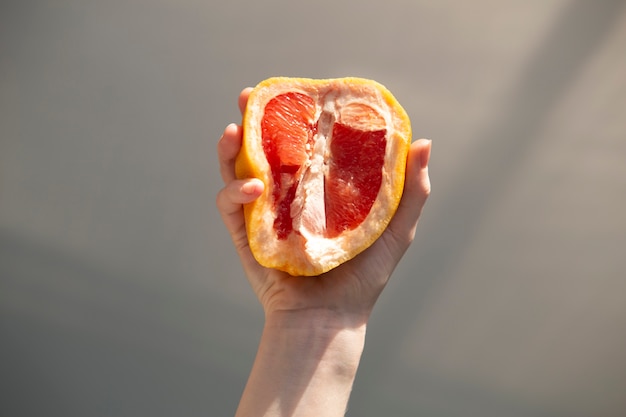 Hand, die halben Pampelmusensommerzeit hält