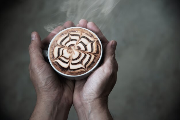 Hand, die heiße Kaffeetasse hält