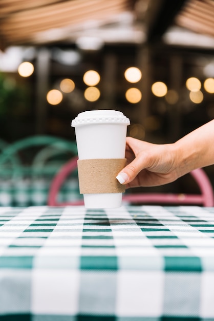 Hand, die Kaffee auf eine Tabelle setzt