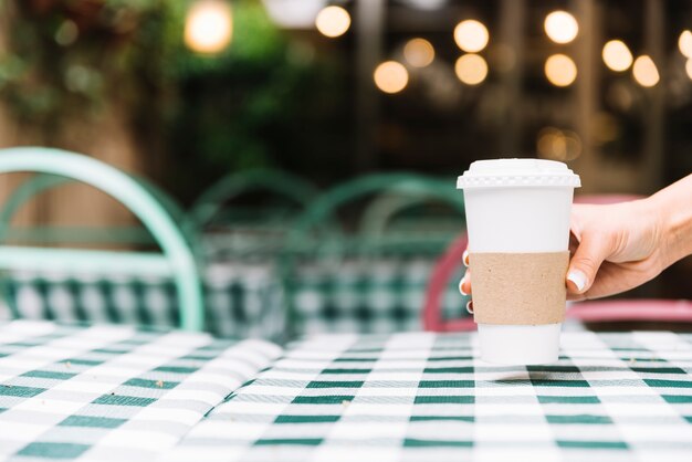 Hand, die Kaffee auf eine Tabelle setzt