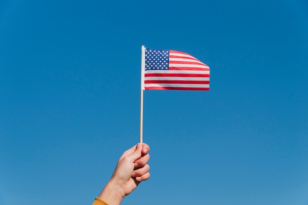Hand, die kleine amerikanische Flagge hält