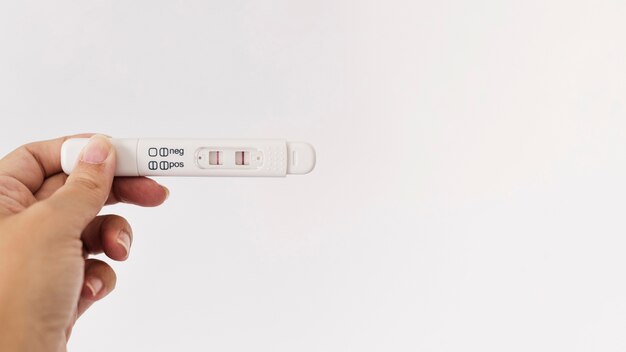 Hand, die positiven Schwangerschaftstest hält
