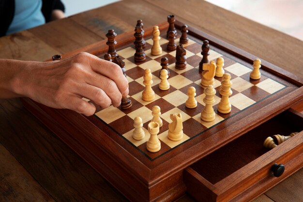 Hand, die Schach auf klassischem Brett spielt