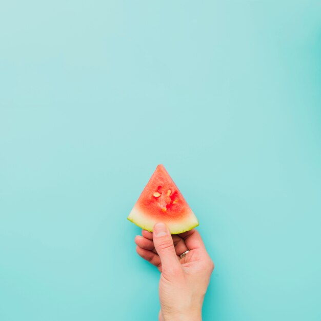 Hand, die Scheibe der Wassermelone hält