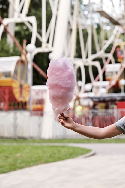 Kostenloses Foto hand, die zuckerwatte-seitenansicht hält