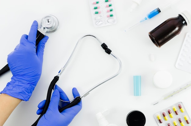Kostenloses Foto hand doktors mit stethoskop und medizinischer ausrüstung auf weißem hintergrund
