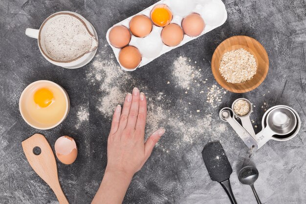 Hand einer Person mit Brotbestandteilen auf schwarzem strukturiertem Hintergrund