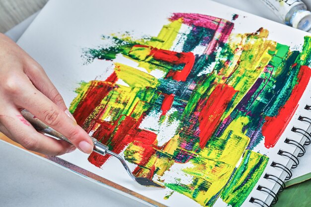 Hand gezeichnete abstrakte Kunst mit Farbtuben auf weißem Tisch.