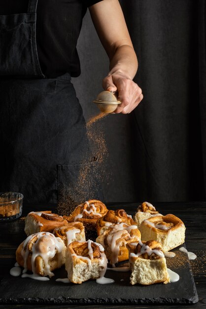 Hand gießen Zimt auf Dessert Nahaufnahme