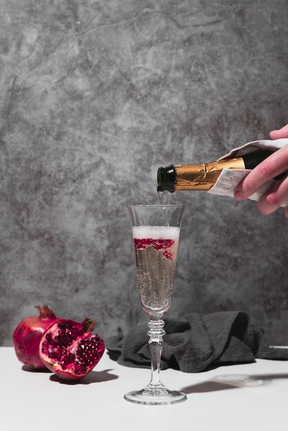 Hand gießt Champagner in Glas
