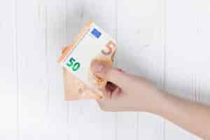 Kostenloses Foto hand hält eine euro-banknote
