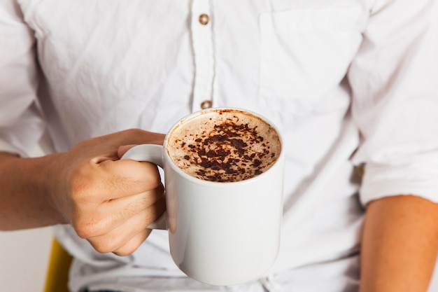 Hand hält eine Kaffeetasse