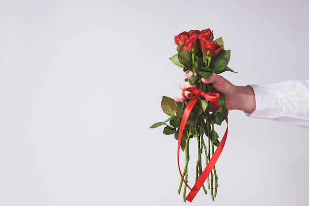 Kostenloses Foto hand hält einen strauß rosen