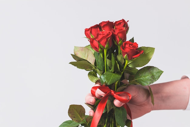 Hand hält einen Strauß Rosen