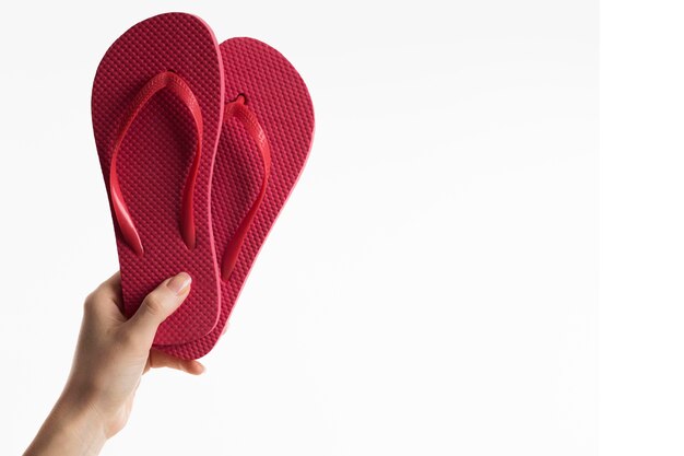 Hand hält Flip-Flops mit Kopierraum