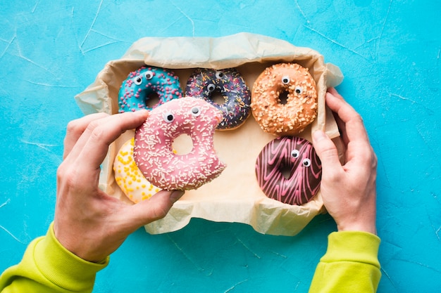 Kostenloses Foto hand hält glasierten donut