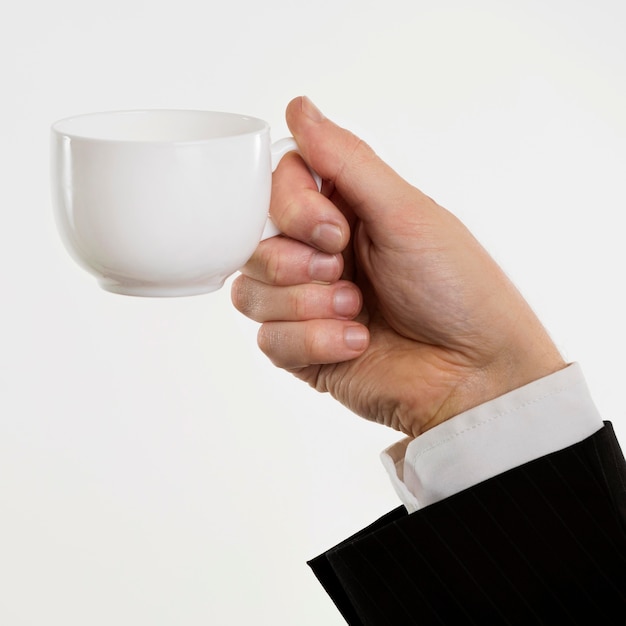 Hand hält Kaffeetasse