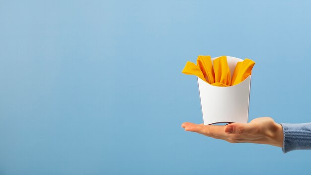 Hand hält Pommes aus Kleidung