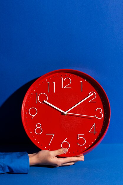 Hand hält Stillleben mit der Wanduhr