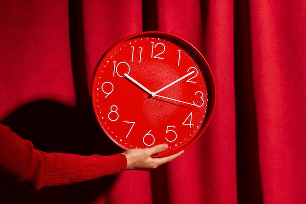 Hand hält Stillleben mit der Wanduhr