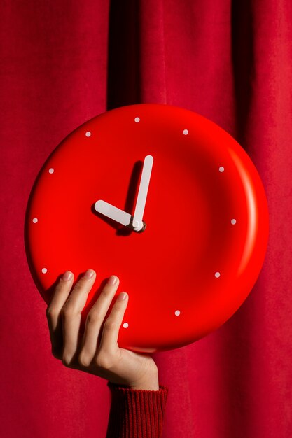 Hand hält Stillleben mit der Wanduhr