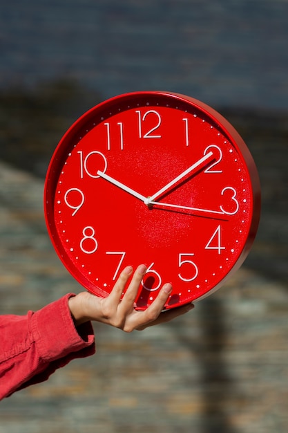 Hand hält Stillleben mit der Wanduhr