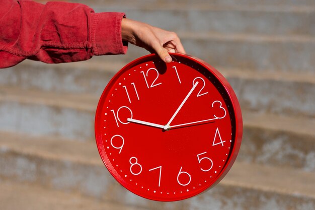 Hand hält Stillleben mit der Wanduhr