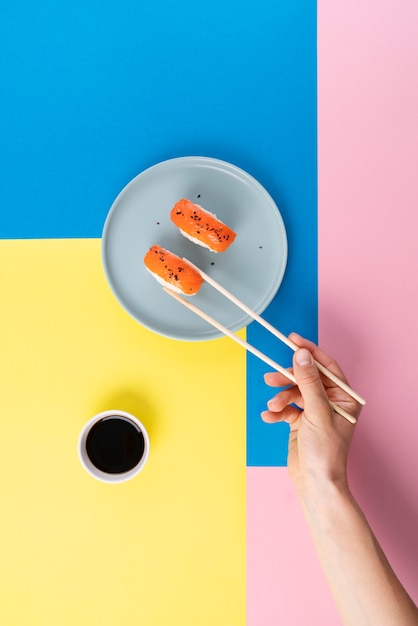 Kostenloses Foto hand hält sushi mit stäbchen hautnah