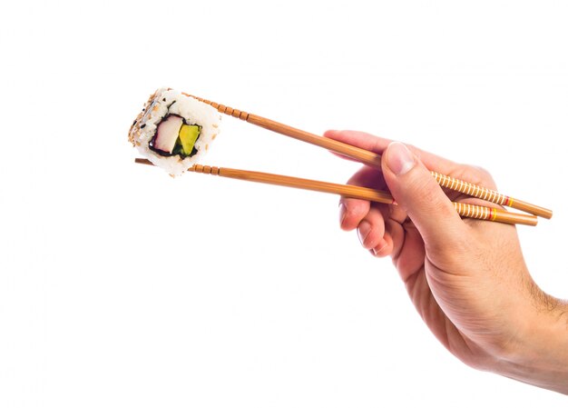 Hand hält Sushi mit Stäbchen