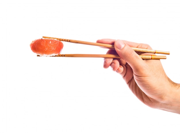 Hand hält Sushi mit Stäbchen
