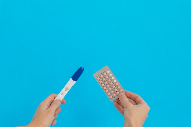 Hand halten empfängnisverhütende Pillen und Schwangerschaftstest