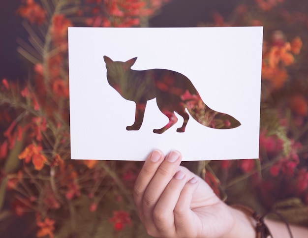 Hand halten Fox Paper Carving mit Blumen-Hintergrund