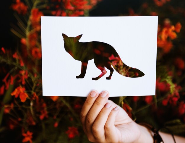 Hand halten Fox-Papier, das mit Natur-Hintergrund schnitzt