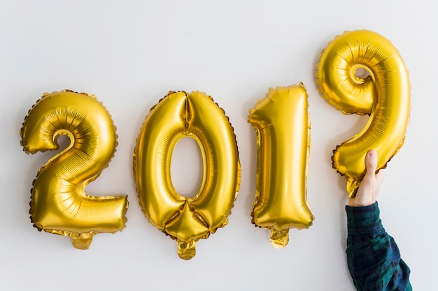 Kostenloses Foto hand in der nähe von ballons zahlen