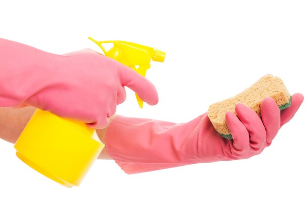 Hand in einem rosa Handschuh, der Spray und Schwamm hält