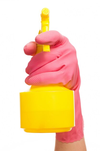 Hand in einem rosa Handschuh, der Sprühflasche hält