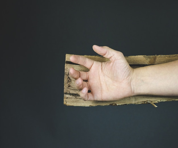 Hand Jesu Christi auf einem Holzkreuz vor dem Nageln