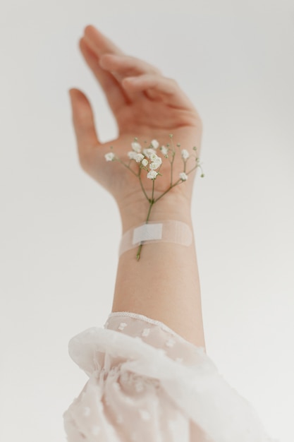 Hand mit Blumen hautnah