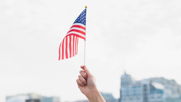 Hand mit der amerikanischen Flagge in der Luft winken