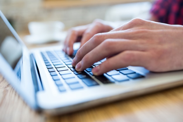 Hand mit einem Laptop in der Kaffeestube