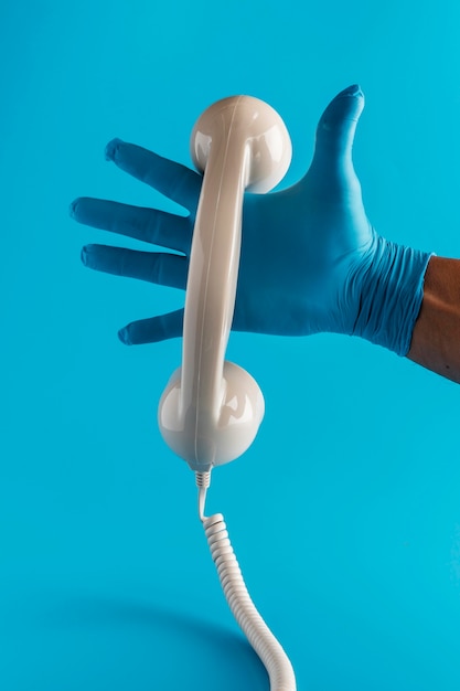 Hand mit Handschuh, der Telefonhörer hält