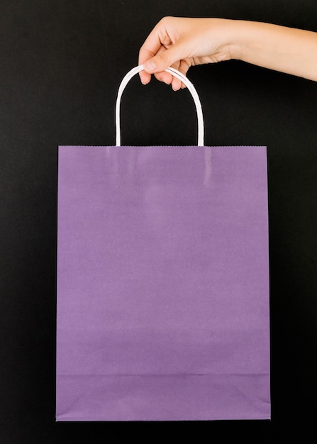 Kostenloses Foto hand mit lila shopping-paket