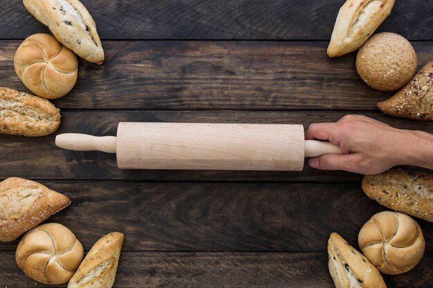 Hand mit Nudelholz auf dem Desktop mit Bäckerei