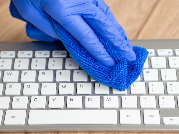 Kostenloses Foto hand mit op-handschuh reinigungstastatur mit tuch